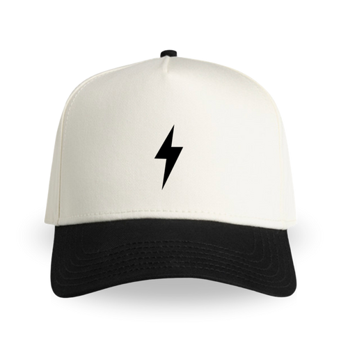 Two-tone hat with a cream crown, black curved brim, and a black lightning bolt centered on the front panel.